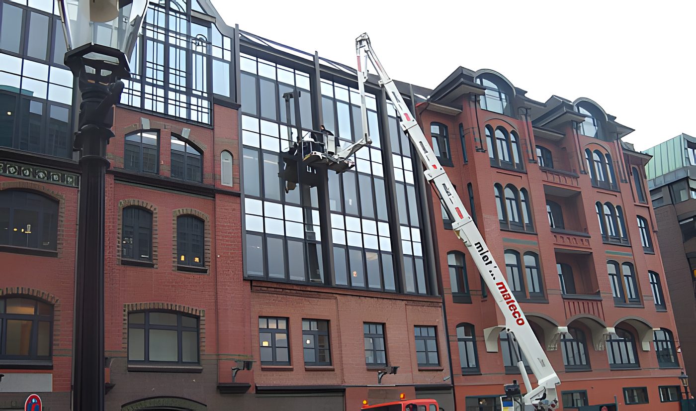 Hubsteiger an der Fassade eines Klinker-Bürogebäudes